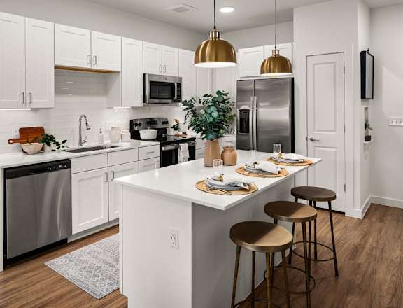 an open kitchen with a center island and stainless steel appliances