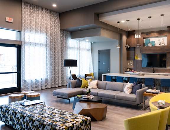 A living room with a grey couch and yellow chairs.