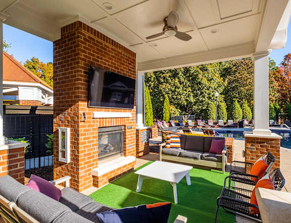 a backyard with a fireplace and a pool with lounge chairs and a table