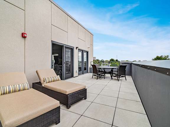 a patio with chairs and a table on a roof