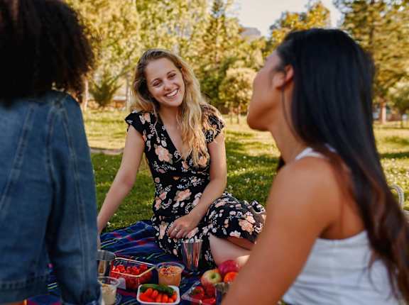 Three women having a picnic in a park.