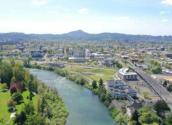A river flows through a city with a bridge crossing over it.
