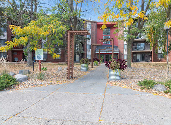 A brick archway leads to a building with a red and white facade.