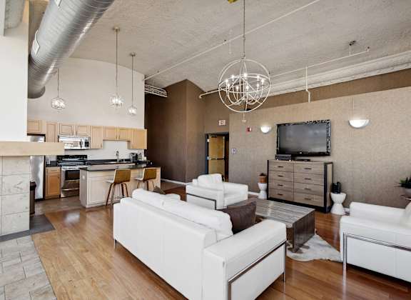 A modern living room with white furniture and a wooden floor.