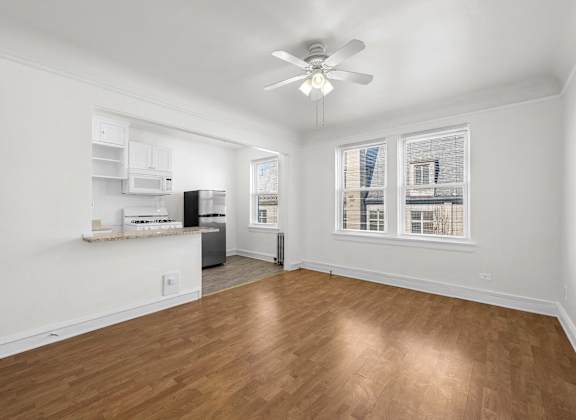 A room with a ceiling fan and wooden flooring at Pleasant Oak Apartments, Oak Park, Illinois