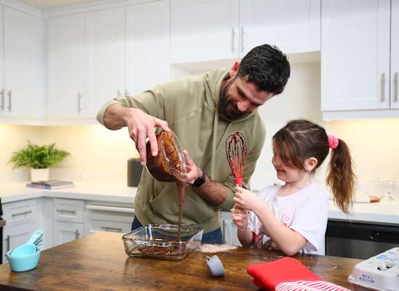 father and daughter baking in kitchen