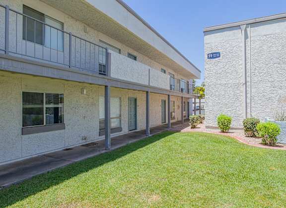 a courtyard with a grassy area and a stone building at Sofia Apartments, Tempe, AZ, 85283