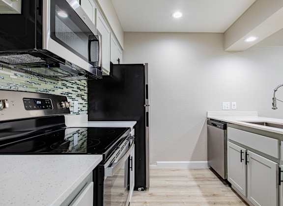 A modern kitchen with black appliances and white countertops. at Sofia Apartments, Tempe, AZ, 85283