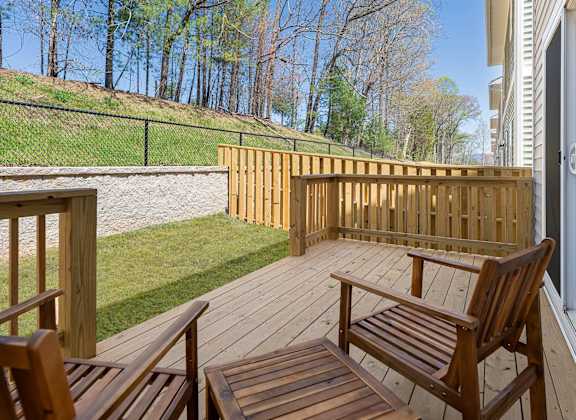 A wooden deck with a bench and a railing.