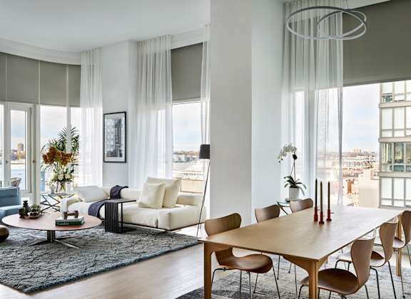 a living room with a dining room table and a large window