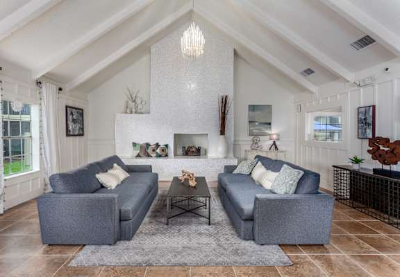 a living room with two couches in front of a fireplace  at Castilian Apartments, Orlando, FL