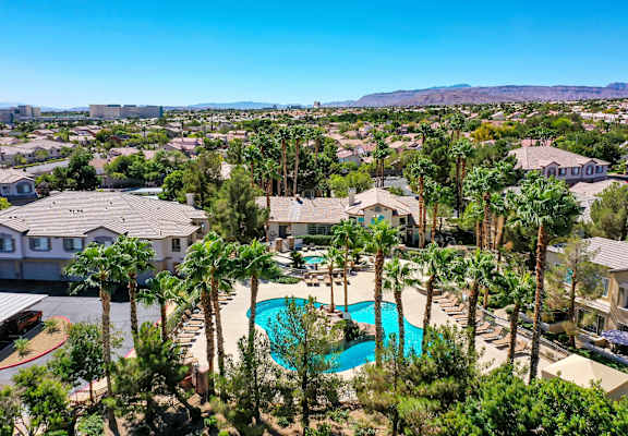 A large house with a pool surrounded by trees.