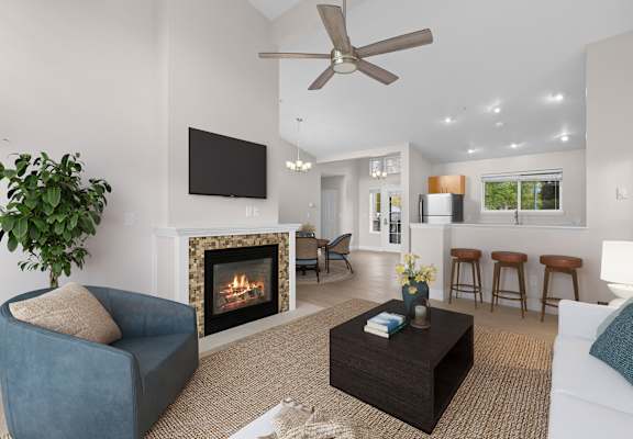 A living room with a fireplace, a blue chair, a white couch, and a ceiling fan.