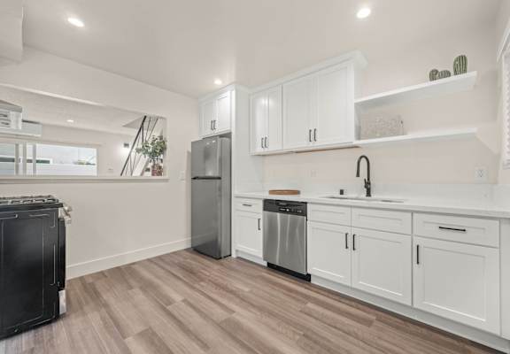 a white kitchen with white cabinets and stainless steel appliances