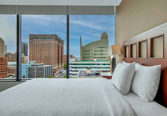 A bedroom with a large bed and a view of the city.