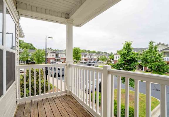 A view from a balcony overlooking a residential street.