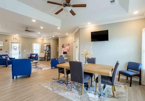 A dining room with a wooden table and blue chairs.