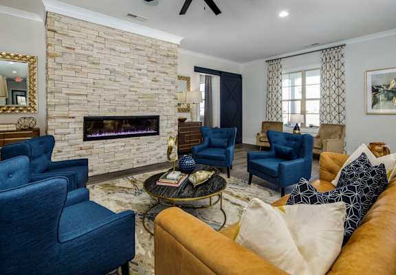 a living room with blue chairs and a fireplace