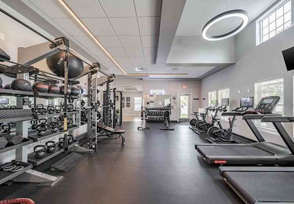 A spacious gym with treadmills, weights, and exercise equipment.