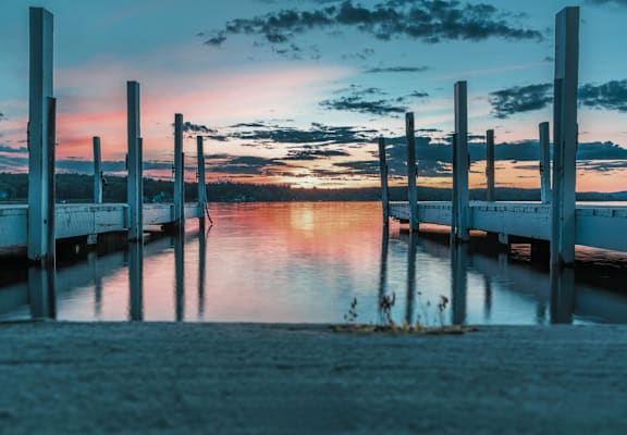 A serene dock with a sunset in the background.