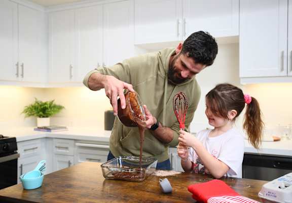 father and daughter baking in kitchen