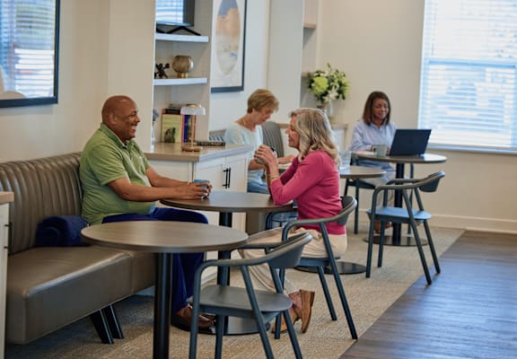 A group of people are sitting around a table in a room.