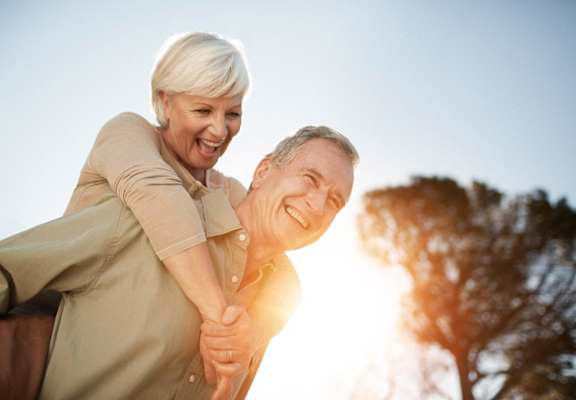 a woman giving a man a piggy back