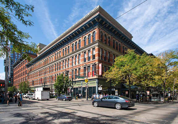 A large red brick building with a green tree in front of it.