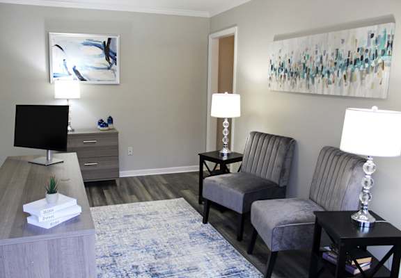 the leasing officd at The Bluffs Apartments with comfortable chairs, a desk, and computer