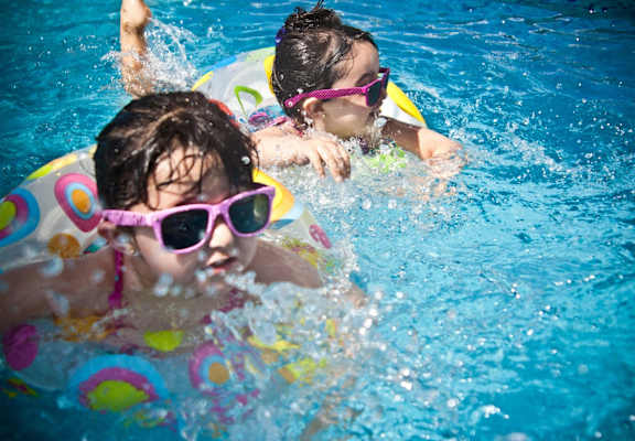 two young girls swimming in a swimming pool