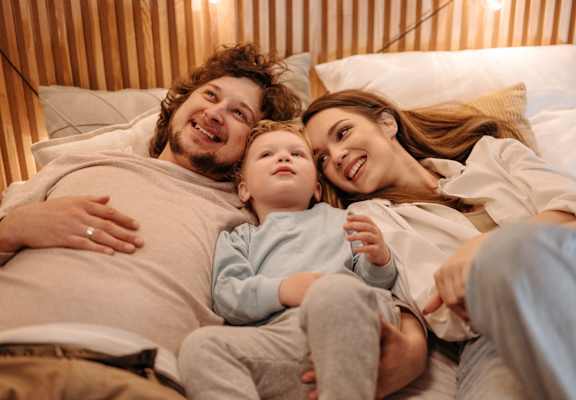 Young Family Laying in Bed at Woodland Villas Apartments in Jasper, AL