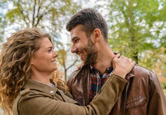 a man and a woman laughing and looking at each other