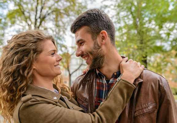 a man and a woman laughing and looking at each other