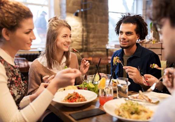 people sitting at a table eating food at a restaurant