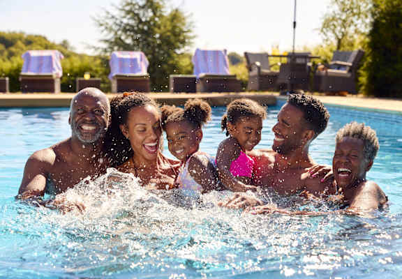 A family of four is enjoying a swim in a pool.