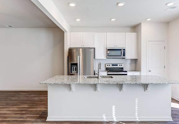 a kitchen with white cabinets and a granite counter top