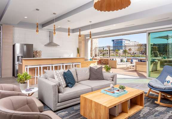 A modern living room with a grey sofa, a wooden coffee table, and a blue chair.