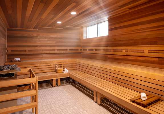A wooden sauna with benches and a window.