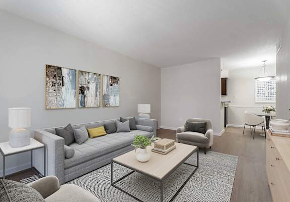 A living room with a grey couch, a coffee table, and a lamp.