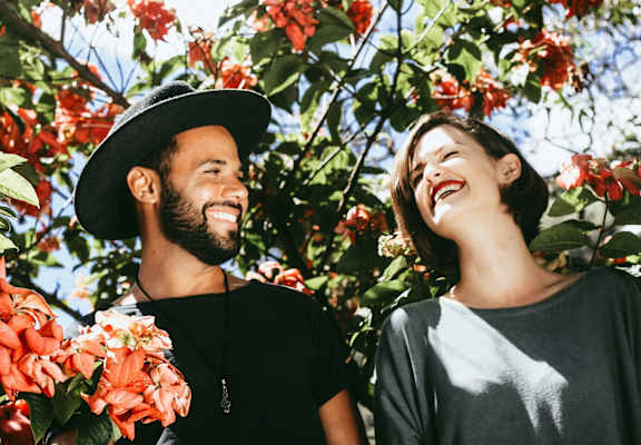 Man and Woman Smiling Outside Under Flowery Tree