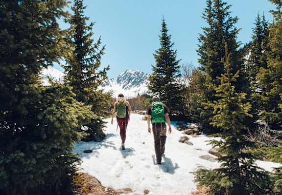 Couple Hiking Through Snowy Forest Mountain