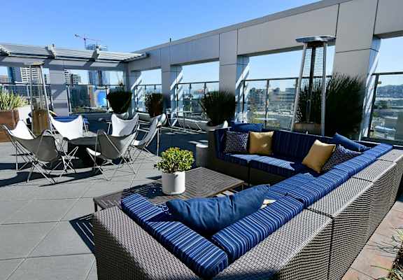 A blue couch with a pillow is on a patio.
