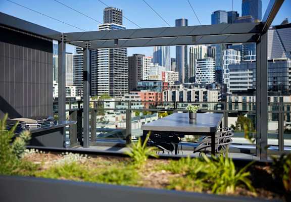 a city view from a balcony with a table and chairs