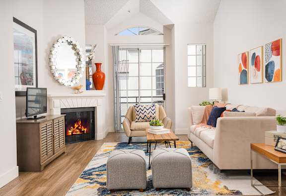 Living room with a large window and a wooden floor at The Preston Miracle Mile Apartments, Los Angeles, 90036