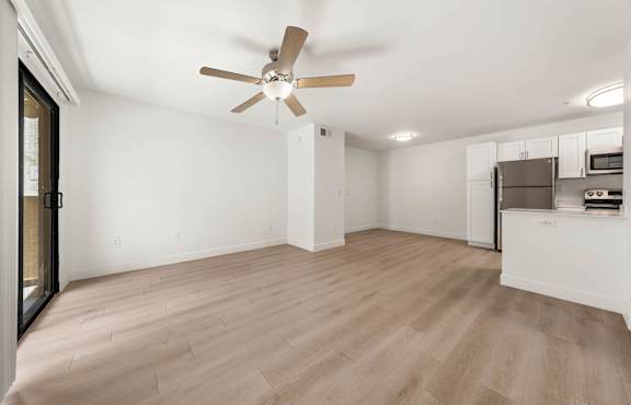 A room with a ceiling fan and light fixture.