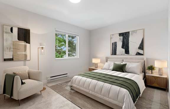A bedroom with a large bed, a chair, and two lamps.