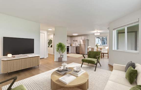 A modern living room with a flat screen TV, a green armchair, and a coffee table with a book and a cup on it.