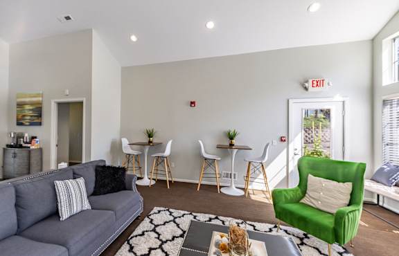 A living room with a grey couch, a green armchair, and a coffee table.