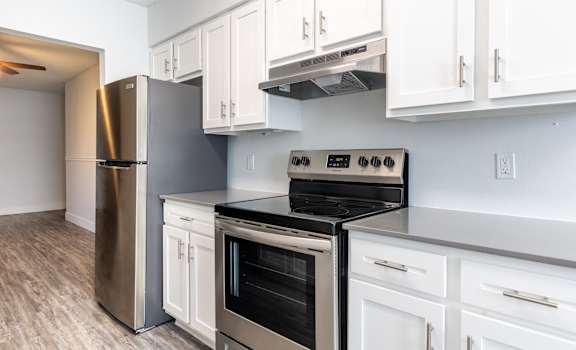 A kitchen with white cabinets and stainless steel appliances.