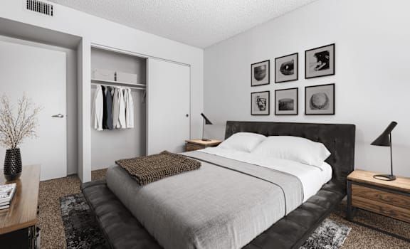 A bedroom with a large bed and a nightstand with a lamp.